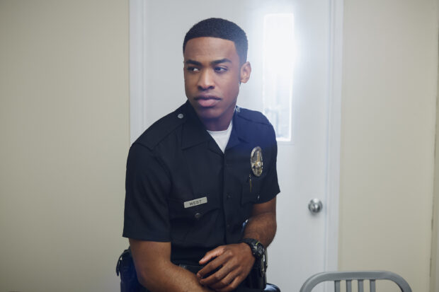 A police officer from The Rookie TV series sits wearing his uniform inside a room, 2K Desktop Wallpaper
