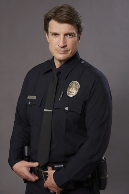 The Rookie Tv Series features a serious police officer in uniform standing confidently, 2K Mobile Wallpaper