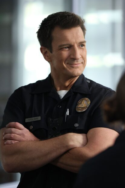 A police officer from The Rookie Tv Series is smiling and crossing his arms, 2K Mobile Wallpaper
