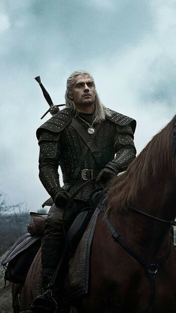 A warrior from The Witcher Tv Series is riding a horse through a misty landscape, 2K Mobile Wallpaper