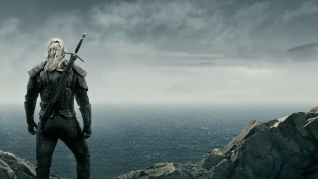 The Witcher Tv Series hero stands on rocky shore looking out over the ocean, HD Desktop Wallpaper