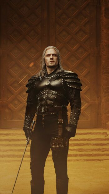 Geralt of Rivia stands in front of an ornate wooden door in The Witcher Tv Series Wallpapers, 2K Mobile Wallpaper