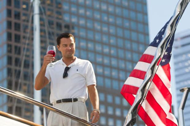 A man celebrating with a glass of wine near an American flag on a yacht, 2K Desktop Wallpaper