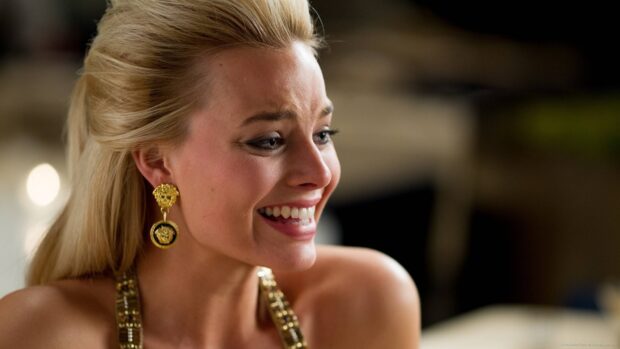 A close up of a woman with gold earrings smiling brightly in a scene from The Wolf Of Wall Street, HD Desktop Wallpaper