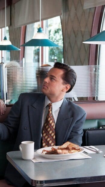A man in a suit sits in a diner with breakfast and coffee The Wolf Of Wall Street Wallpapers, HD Mobile Wallpaper