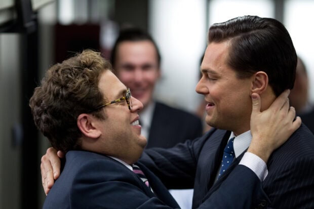 Two men share a joyful embrace in a professional setting from The Wolf Of Wall Street, 2K Desktop Wallpaper