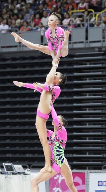 Three acrobats showcase strength and balance in acrobatic gymnastics, HD Mobile Wallpaper