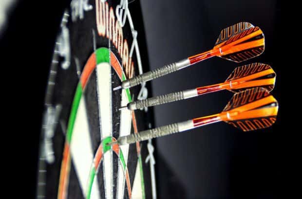 Three darts hitting the bullseye on a dartboard in a close up shot, HD Desktop Wallpaper