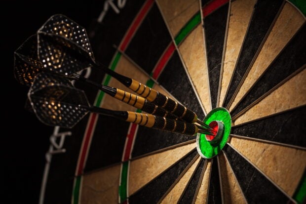 Three darts hitting the bullseye on the dartboard in a close up view, HD Desktop Wallpaper