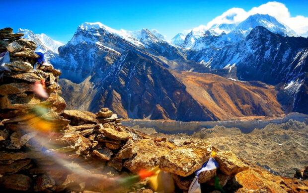The Tibetan Highlands feature rugged snow capped peaks under a bright blue sky, 2K Desktop Wallpaper