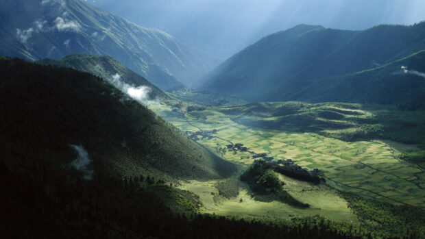 The Tibetan highlands valley shows lush green fields and misty mountains, HD Desktop Wallpaper