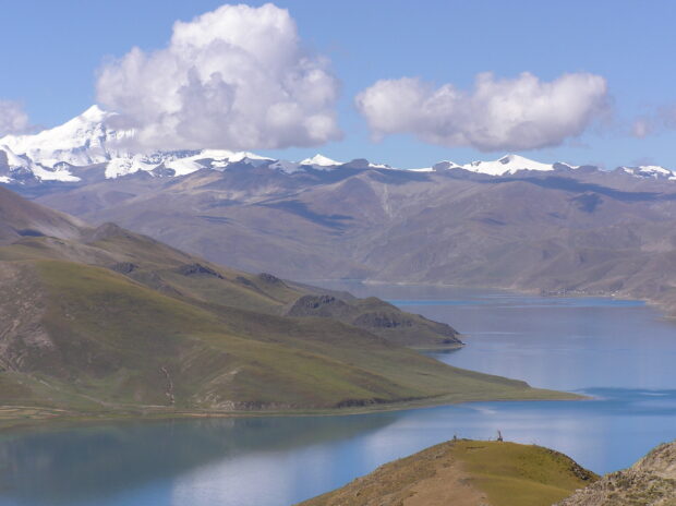 The view shows Tibetan highlands with snow covered mountains and a peaceful lake, HD Desktop Wallpaper