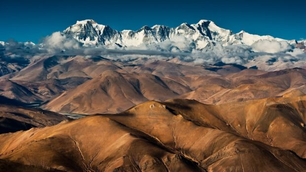 The Tibetan Highlands feature vast mountain ranges under a clear blue sky, HD Desktop Wallpaper