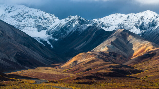 The Tibetan highlands extend under cloudy skies with colorful hills in foreground, HD Desktop Wallpaper