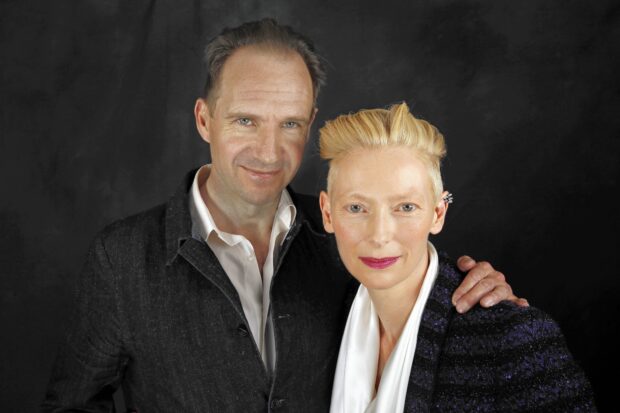 A close up of Tilda Swinton and a man posing together in front of a black background, HD Desktop Wallpaper