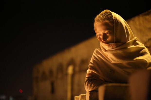 Tilda Swinton in a shawl leaning thoughtfully against a railing at night, HD Desktop Wallpaper