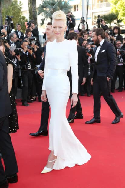 Tilda Swinton stands on the red carpet wearing a white elegant gown, HD Desktop Wallpaper