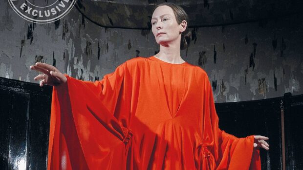 A portrait of Tilda Swinton wearing a flowing orange dress with an abstract background, HD Desktop Wallpaper