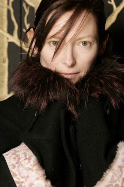A close up portrait of Tilda Swinton wearing a fur collared coat in front of a decorative background, HD Mobile Wallpaper