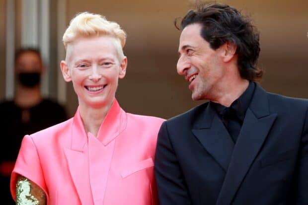 Tilda Swinton smiles warmly standing next to a man in a dark suit, 2K Desktop Wallpaper