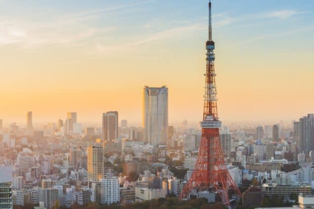 The Tokyo Tower stands tall among city buildings during sunset in Tokyo, 2K Desktop Wallpaper