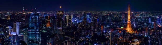 The Tokyo Tower shines brightly among city lights under the full moon, 4K Desktop Wallpaper