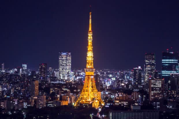 Japan, The Tokyo Tower lit up at night stands tall among the city skyline in Tokyo, Japan, 2K Desktop Wallpaper