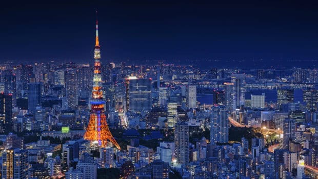 The Tokyo Tower stands brightly illuminated among the city skyline, 4K Desktop Wallpaper