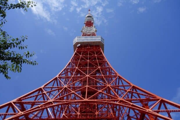 The red Tokyo Tower stands tall under a bright blue sky with scattered clouds, 2K Desktop Wallpaper