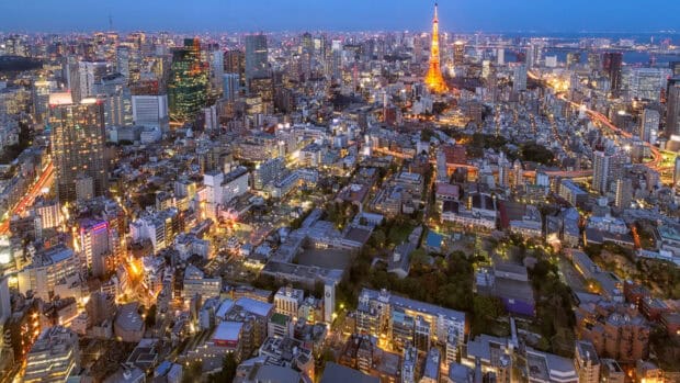 The Tokyo Tower stands bright above the city lights in this view of Tokyo cityscape, 2K Desktop Wallpaper