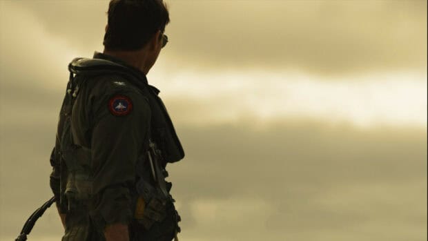 A Top Gun Maverick pilot is standing and looking at the cloudy sky, HD Desktop Wallpaper