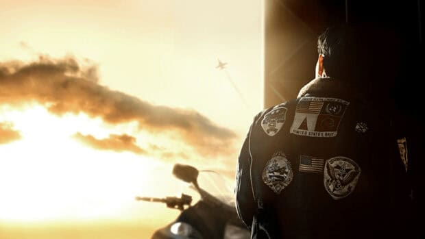A pilot from Top Gun Maverick watches a jet flying through the sky during sunset, HD Desktop Wallpaper