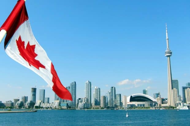 The CN Tower and Canadian flag are visible over Toronto's waterfront skyline, 2K Desktop Wallpaper