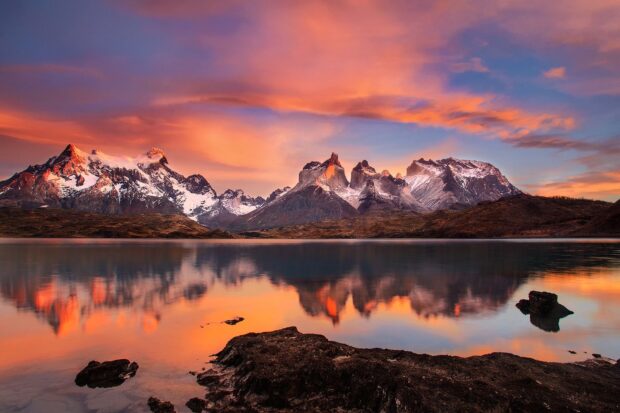 The snow capped peaks of Torres Del Paine National Park reflect on the calm lake during sunset, HD Desktop Wallpaper