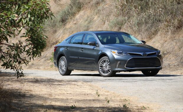 A gray Toyota Avalon is parked on a rural road surrounded by dry hills and greenery, HD Desktop Wallpaper