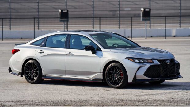A sleek white Toyota Avalon is parked on a large paved area under clear skies, HD Desktop Wallpaper