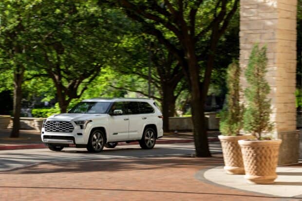 A white Toyota Sequoia is driving on a tree lined urban road in this image, HD Desktop Wallpaper