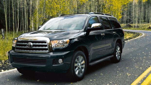 A black Toyota Sequoia driving on a road surrounded by trees with yellow leaves, HD Desktop Wallpaper