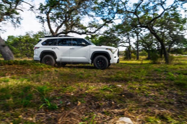 A white Toyota Sequoia driving fast on a grassy forest trail, 2K Desktop Wallpaper