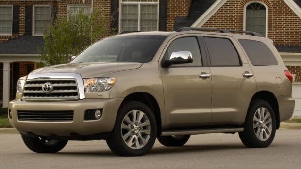 A beige Toyota Sequoia is parked on a street in front of a brick house, HD Desktop Wallpaper