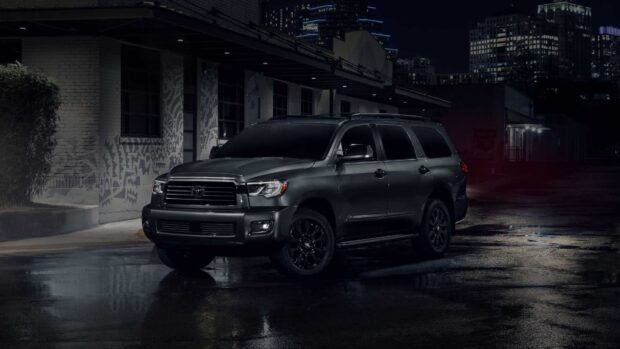 A Toyota Sequoia is parked on a wet street with city lights in the background, HD Desktop Wallpaper