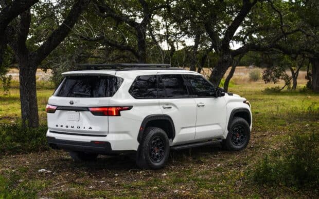 A white Toyota Sequoia is parked outdoors surrounded by trees and grass, HD Desktop Wallpaper
