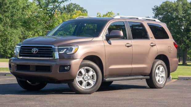 A Toyota Sequoia stands parked on pavement with green trees in the background, HD Desktop Wallpaper