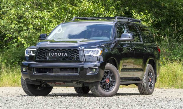 A black Toyota Sequoia stands on gravel with greenery in the background, HD Desktop Wallpaper