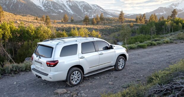 A silver Toyota Sequoia is parked on a dirt road surrounded by trees and mountains, 2K Desktop Wallpaper