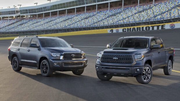 Two Toyota Sequoia vehicles parked side by side at Charlotte racetrack under clear sky, 2K Desktop Wallpaper