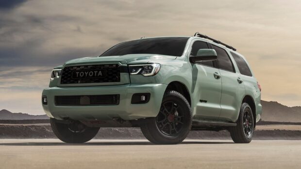 A Toyota Sequoia is parked on a sandy road with mountains in the background under a cloudy sky, HD Desktop Wallpaper