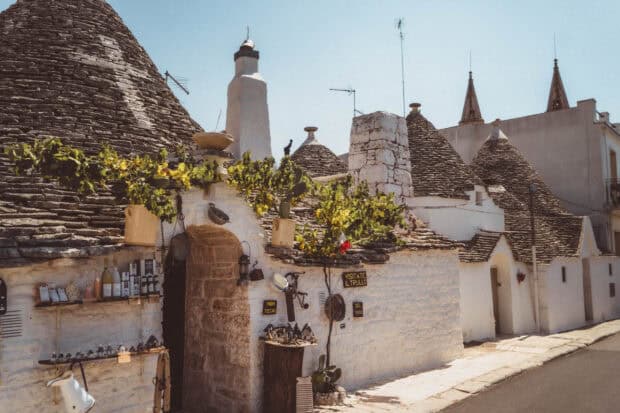 The Alberobello houses with unique stone roofs are seen under a clear sky, 2K Desktop Wallpaper