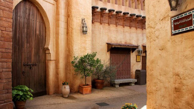 A traditional Moroccan street with potted plants and wooden doors showcasing Morocco wallpapers, 2K Desktop Wallpaper