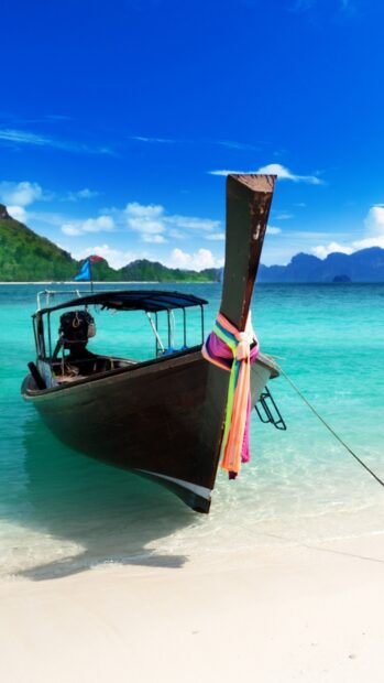 A traditional Thai boat floats in the clear turquoise waters near Phuket with green hills in the background, HD Phone Wallpaper
